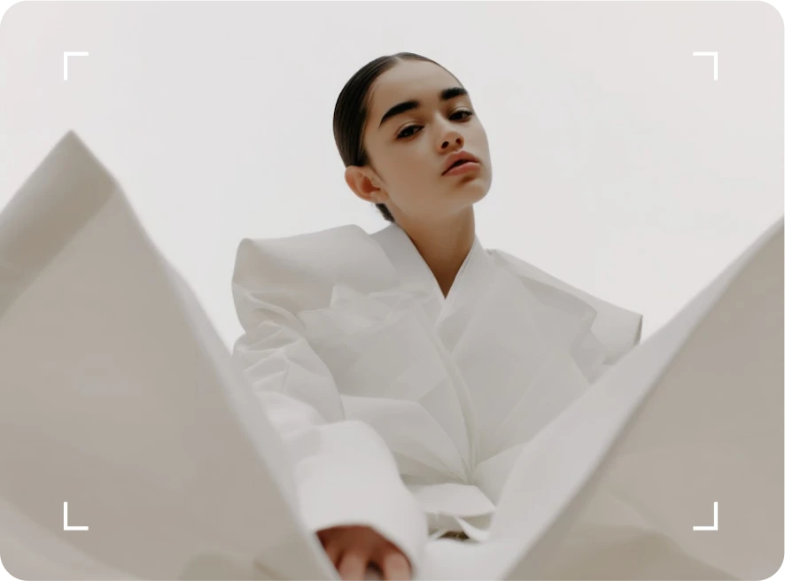 A woman in a white shirt looking up at the sky.